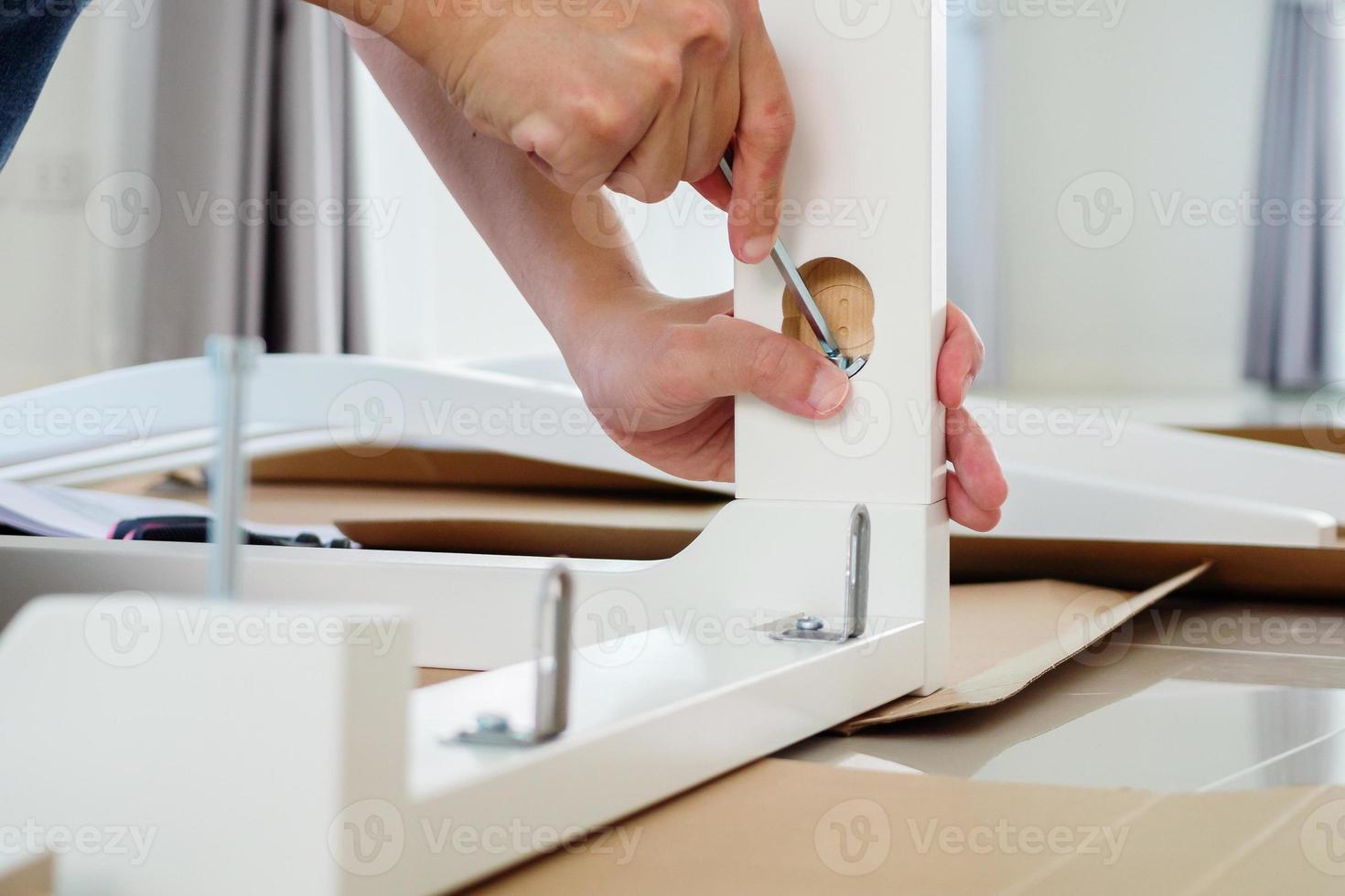 hombre montando muebles de silla blanca en casa foto