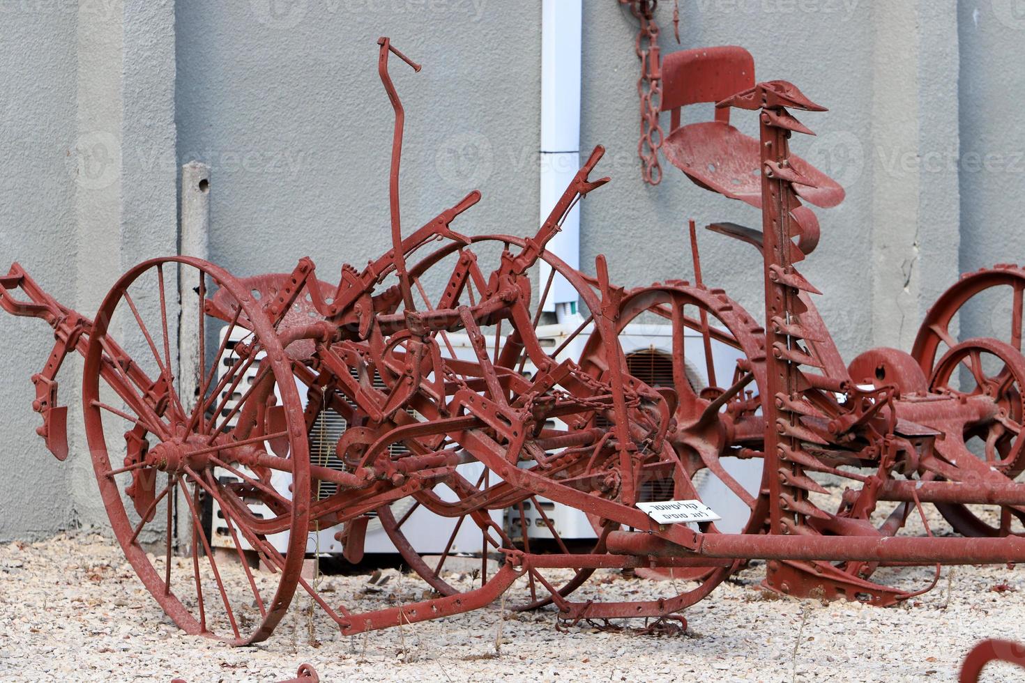 Old agricultural machinery stands on the street in Israel and rusts photo