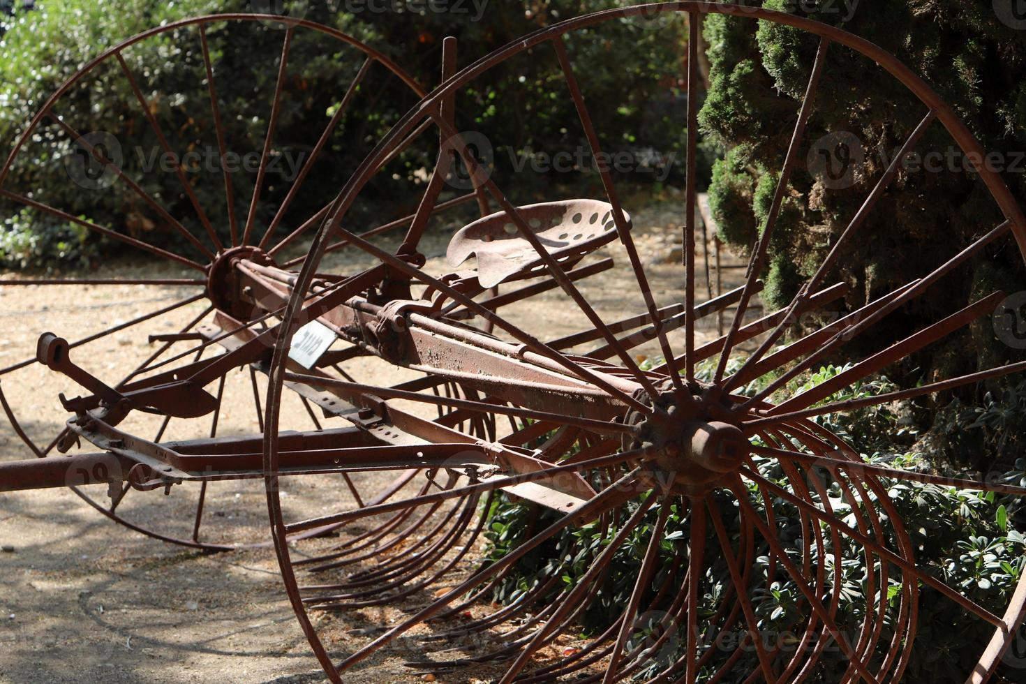 Old agricultural machinery stands on the street in Israel and rusts photo