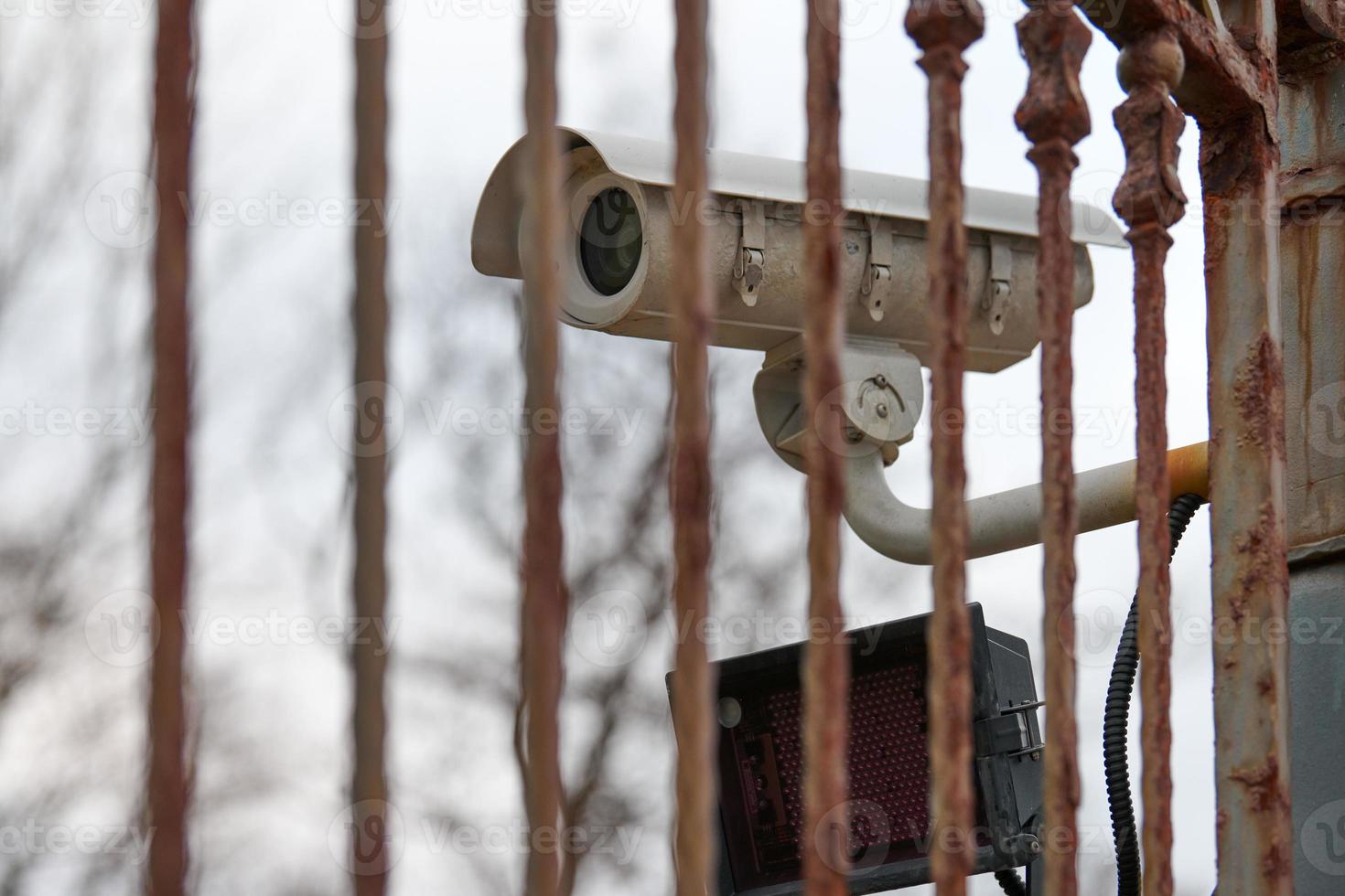 IP CCTV security camera and iron fence, urban cityscape photo