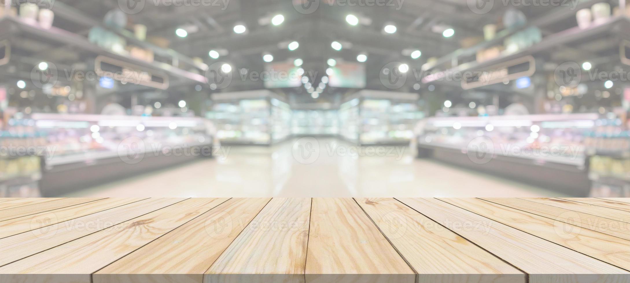 Wood table top with supermarket grocery store blurred defocused background with bokeh light for product display photo