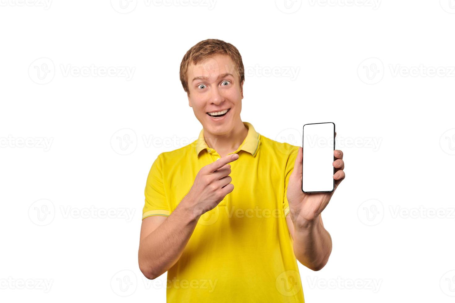 Smiling young man with smartphone mockup in hand, white isolated background, mobile app advertise photo