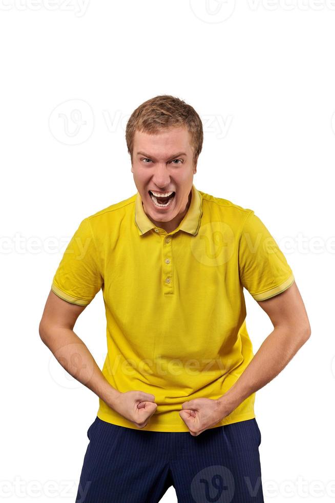 Funny young guy in casual yellow T-shirt raising hands successful and aggressive isolated on white photo