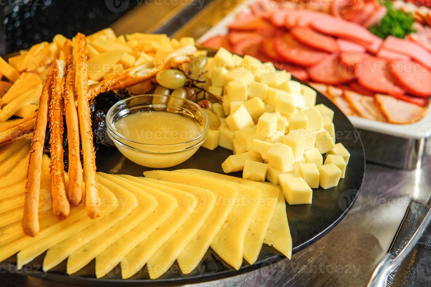 un plato de queso con miel en una mesa buffet foto