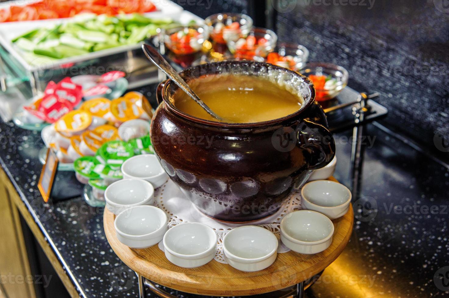 un tazón de puré de sopa en una mesa de buffet con tazones pequeños alrededor foto