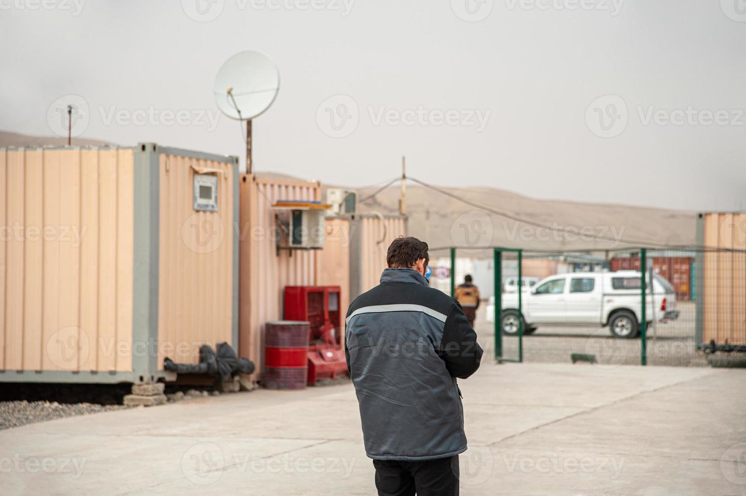 una vista trasera de un hombre caminando por contenedores de alojamiento foto