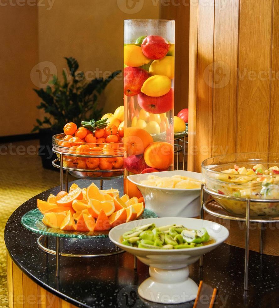 una toma vertical de una mesa de buffet con tazones de frutas para la exhibición de productos foto