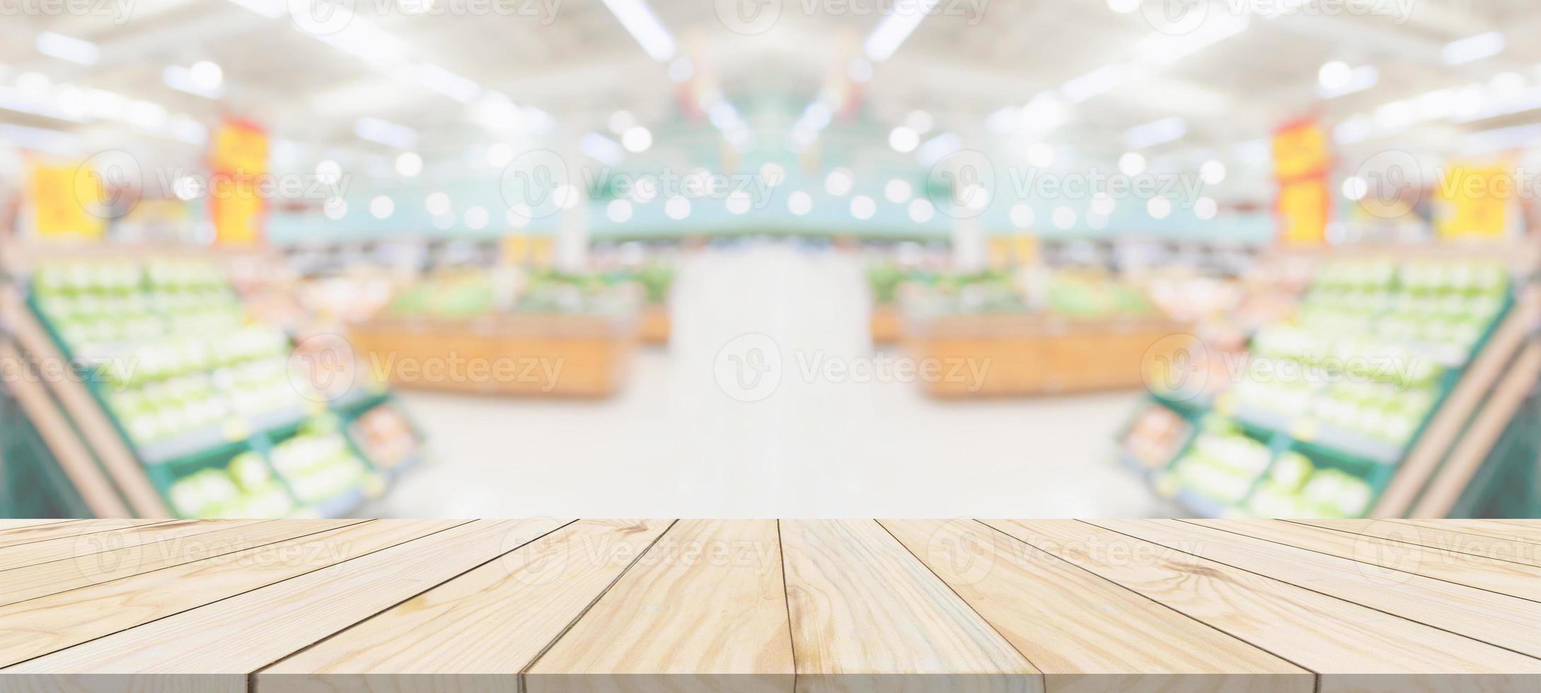 Wood table top with supermarket grocery store blurred defocused background with bokeh light for product display photo