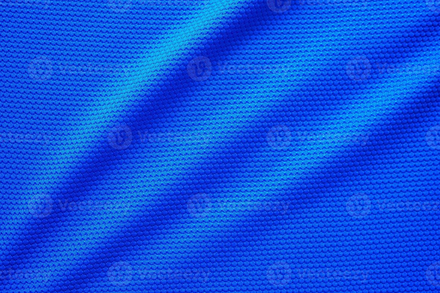 Blue football jersey clothing fabric texture sports wear background, close up top view photo