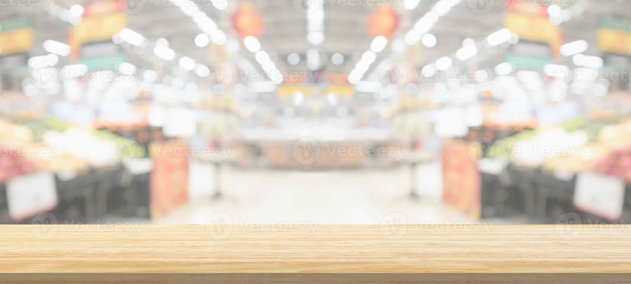 Wood table top with supermarket grocery store blurred defocused background with bokeh light for product display photo