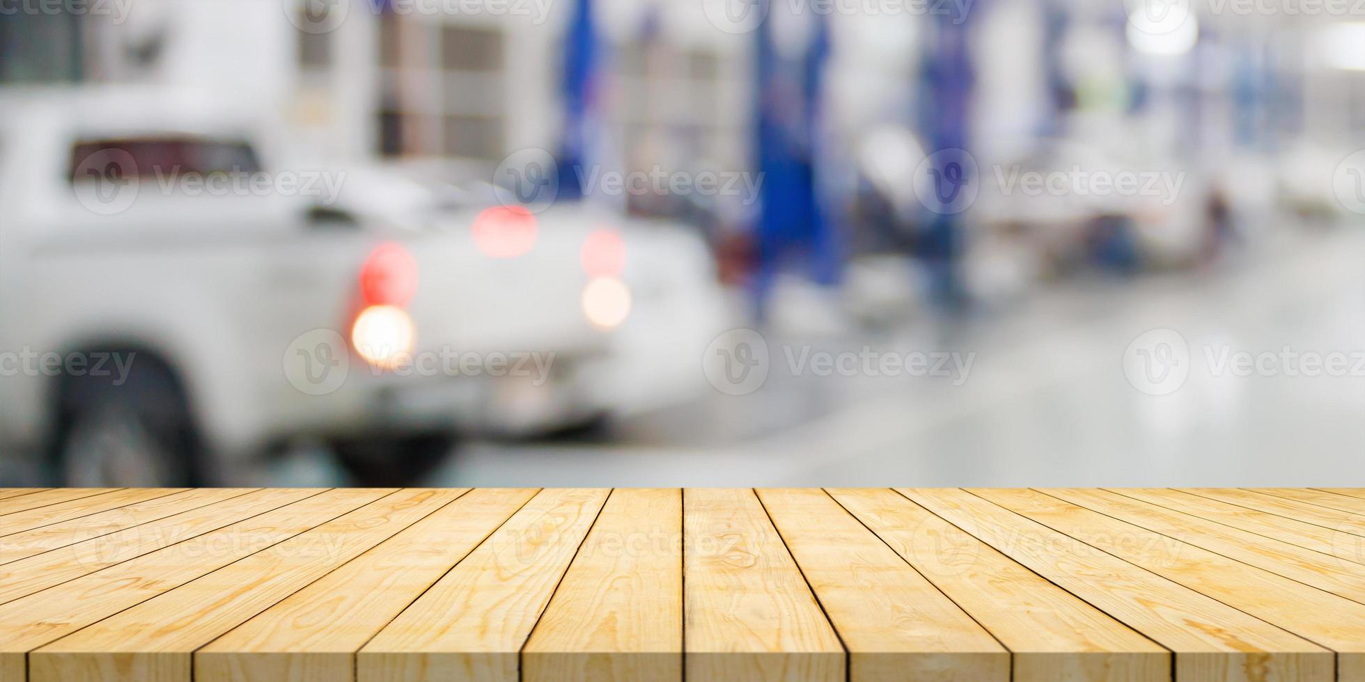 Empty wood table top with car service centre auto repair workshop blurred background photo