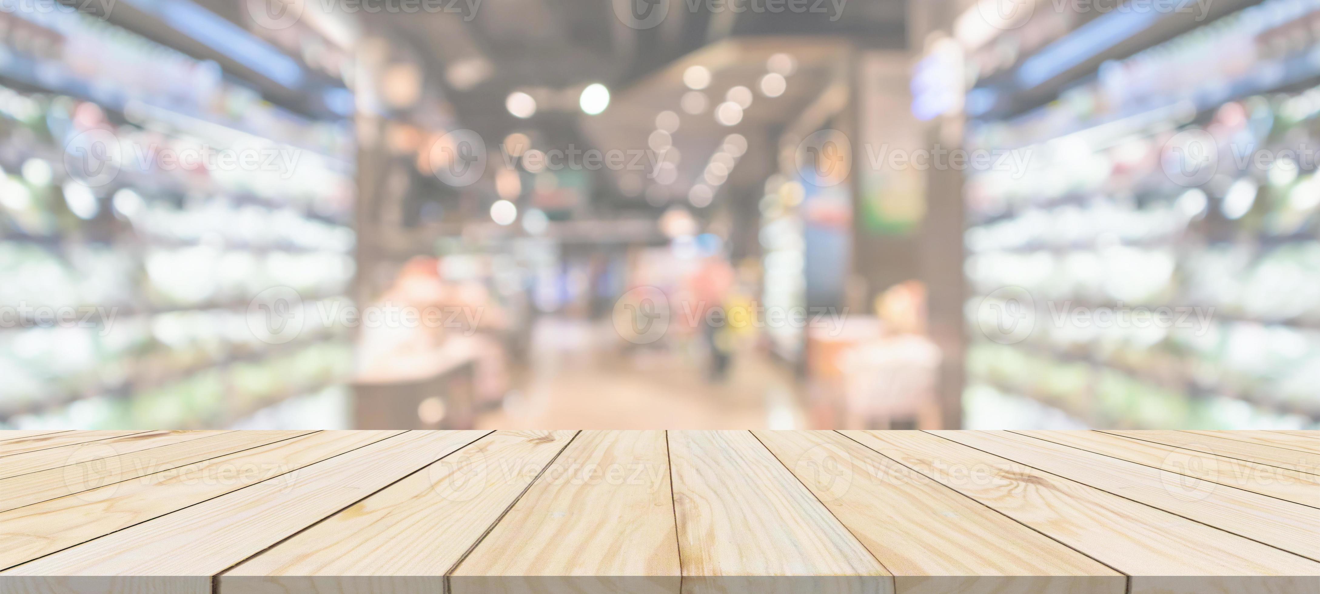 Wood table top with supermarket grocery store blurred background with