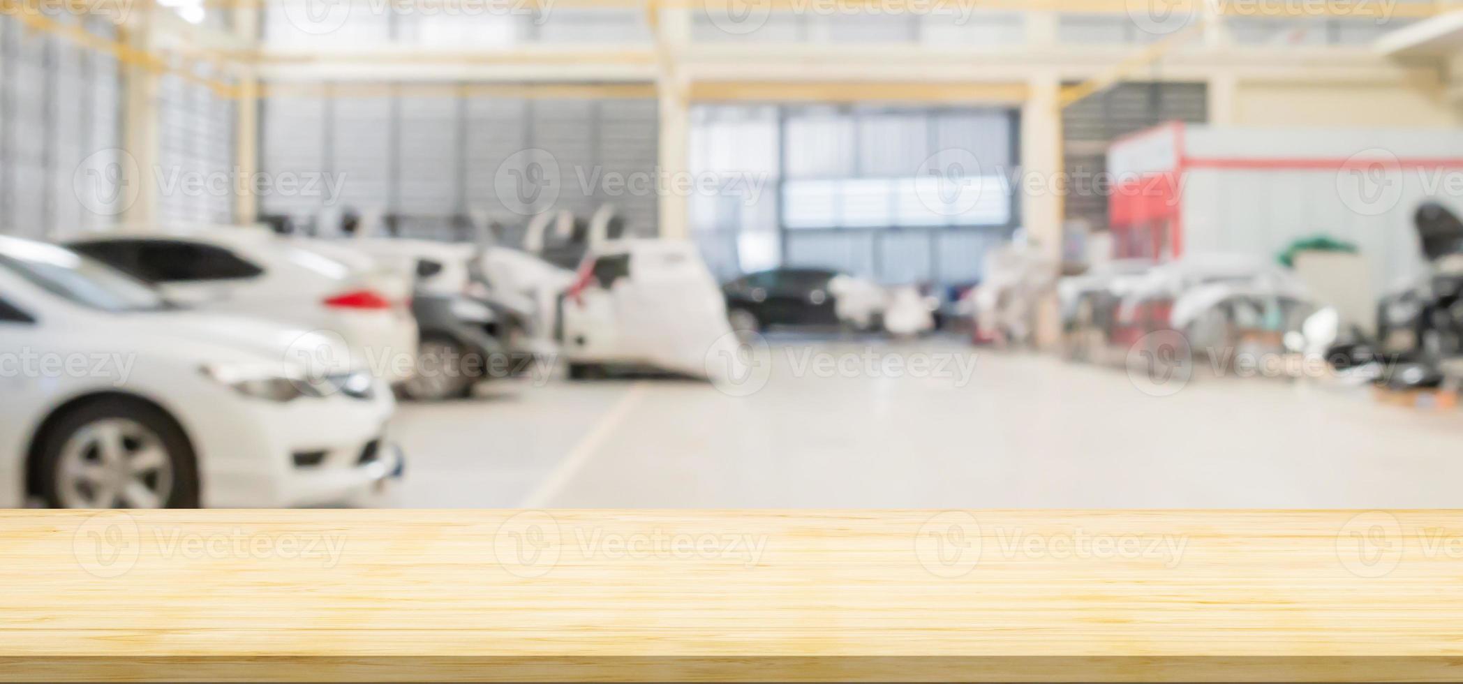 Empty wood table top with car service centre auto repair workshop blurred background photo