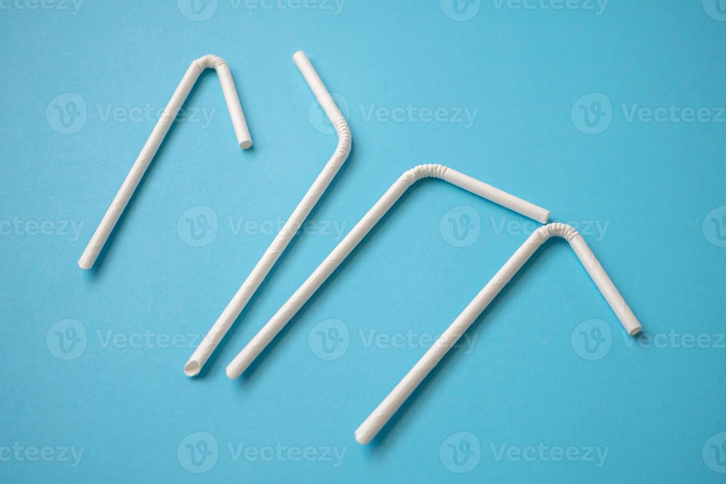 Biodegradable eco friendly white paper drinking straw on blue background photo