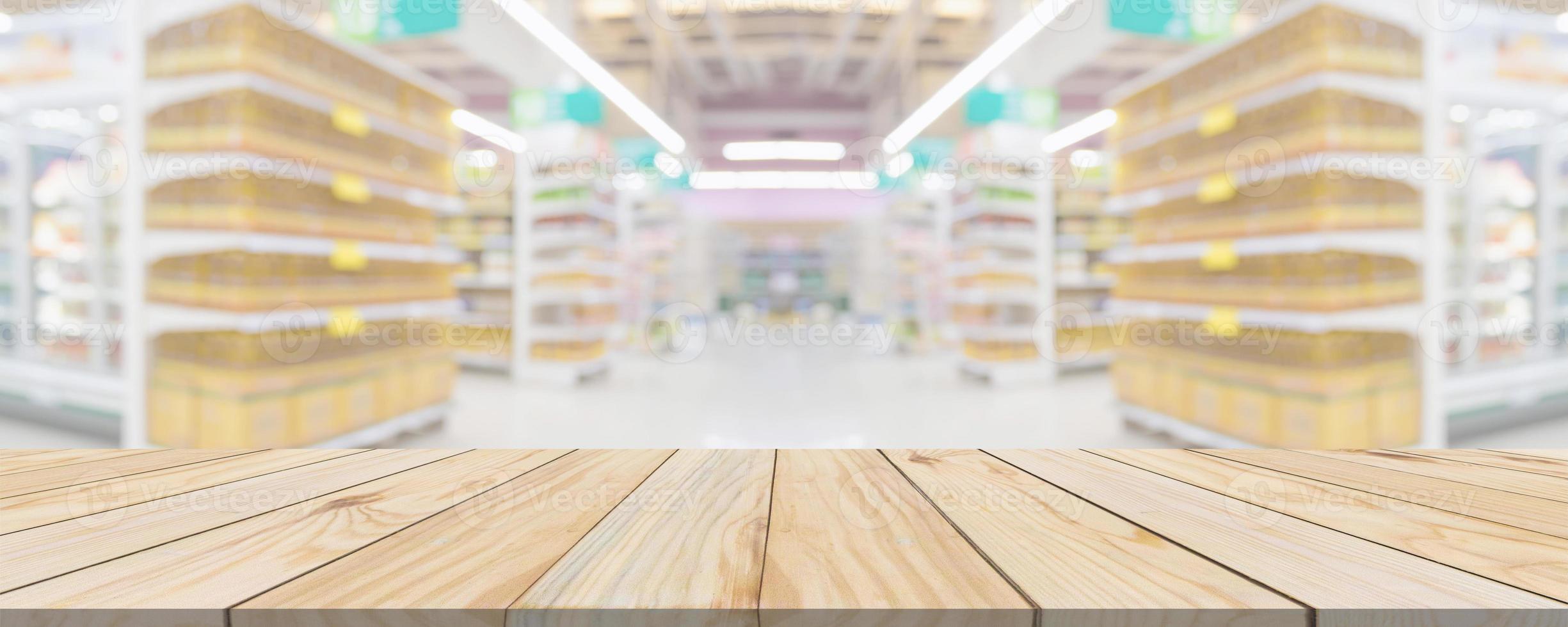 Wood table top with supermarket grocery store aisle interior blurred background with bokeh light for product display photo