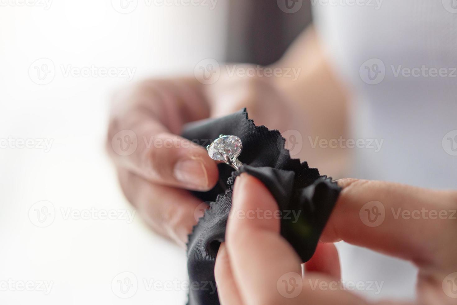 joyero limpieza anillo de diamantes de joyería con paño de tela foto