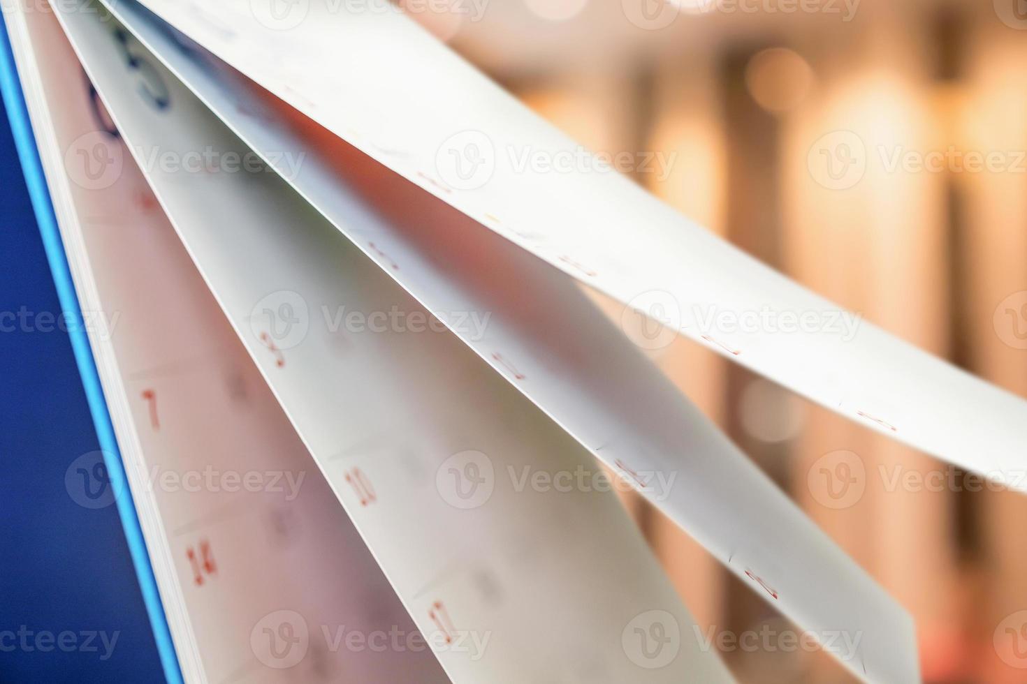 Close up white paper desk calendar with blurred bokeh background appointment and business meeting concept photo