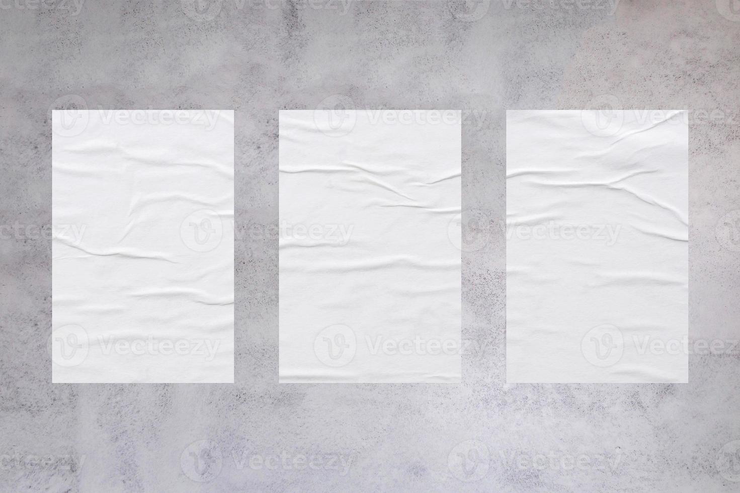 Blank white wheatpaste glued paper poster mockup on concrete wall background photo