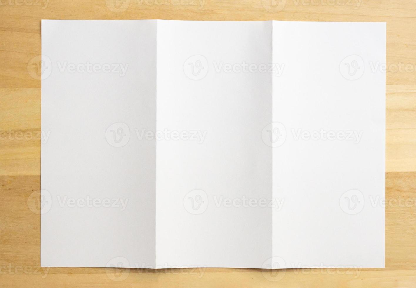 White folded paper on wood table background photo