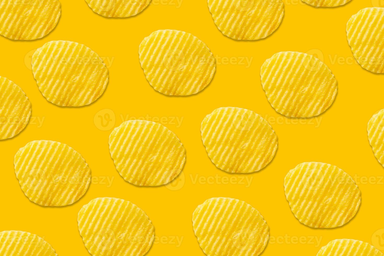 Potato chips pattern on yellow background top view flat lay photo
