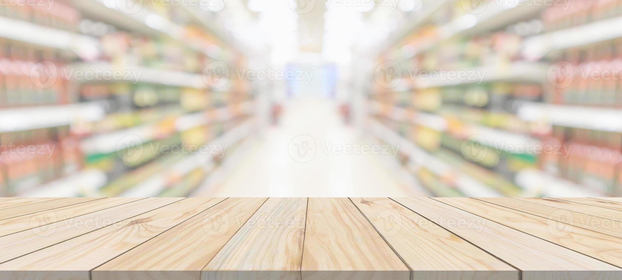 Wood table top with supermarket grocery store aisle interior blurred background with bokeh light for product display photo