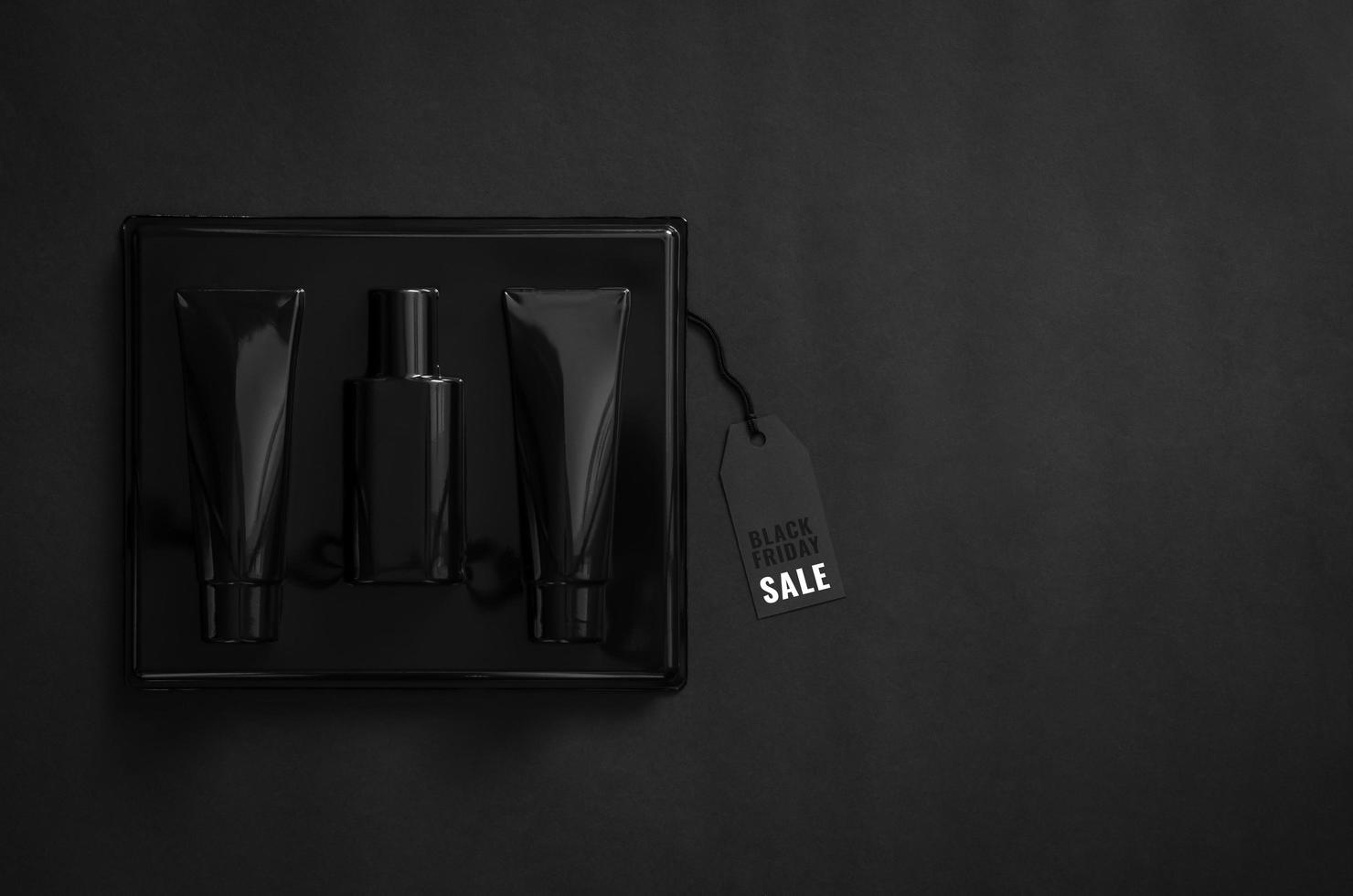 A black box of perfume with black price tag on black background. Black Friday concept. photo