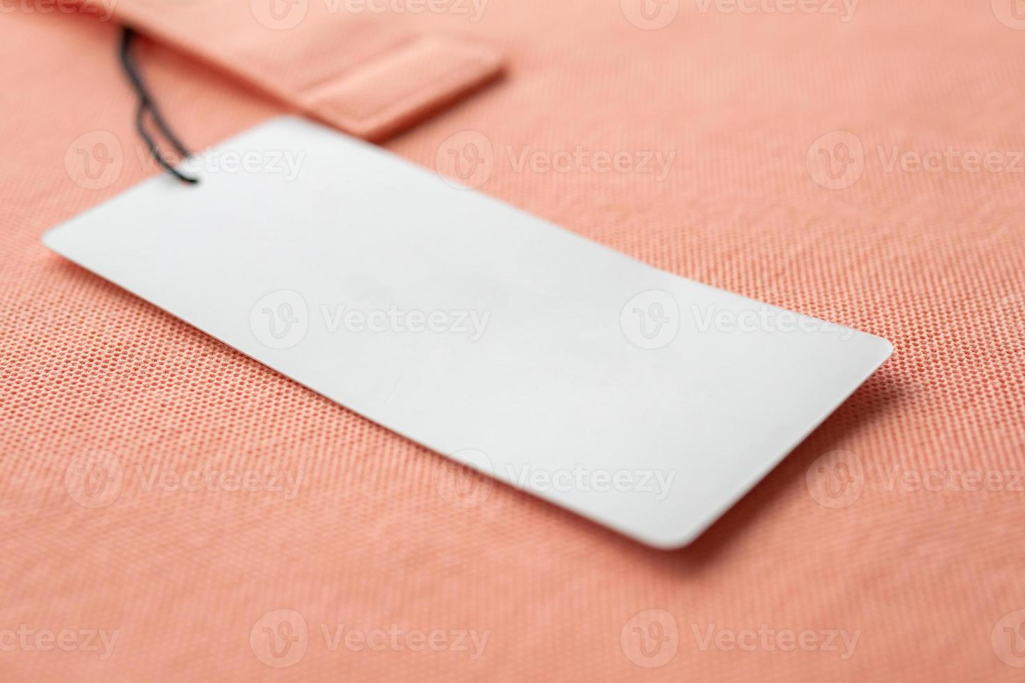 etiqueta de etiqueta de ropa blanca en blanco sobre fondo de textura de tela rosa foto