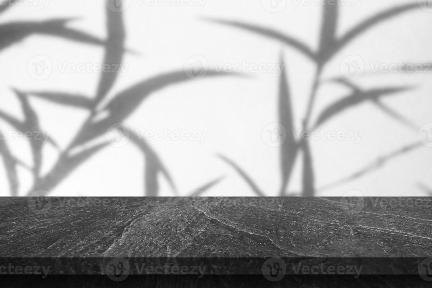 mesa de mármol con caída de sombra de árbol sobre fondo de pared blanca para exhibición de productos de maqueta foto