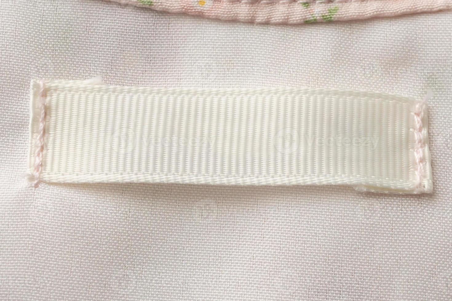 Blank laundry care clothes label on fabric texture background photo