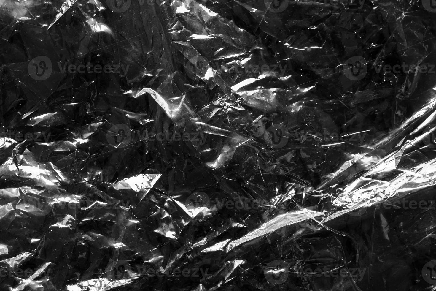 transparent plastic bag film wrap overlay texture on black background photo