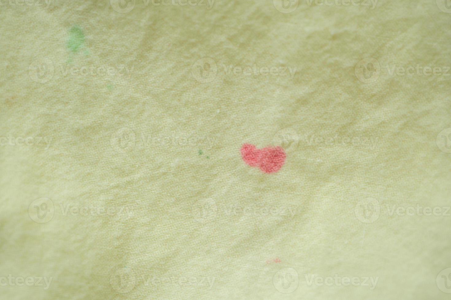 dirty color stain on yellow fabric texture background photo