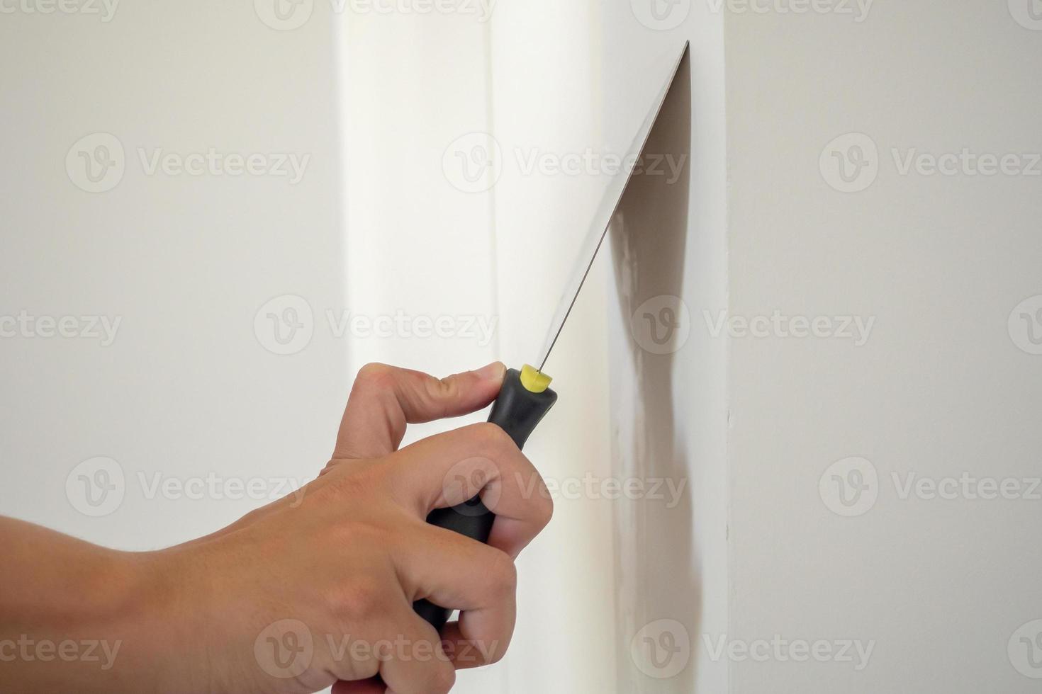 Man repairing crack white wall with spatula photo