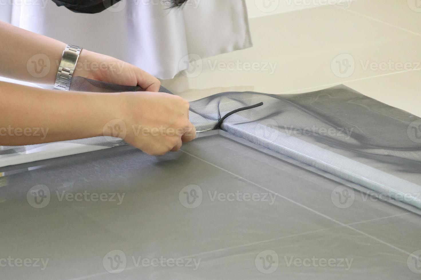 man install mosquito net wire screen on house window protection against insect photo