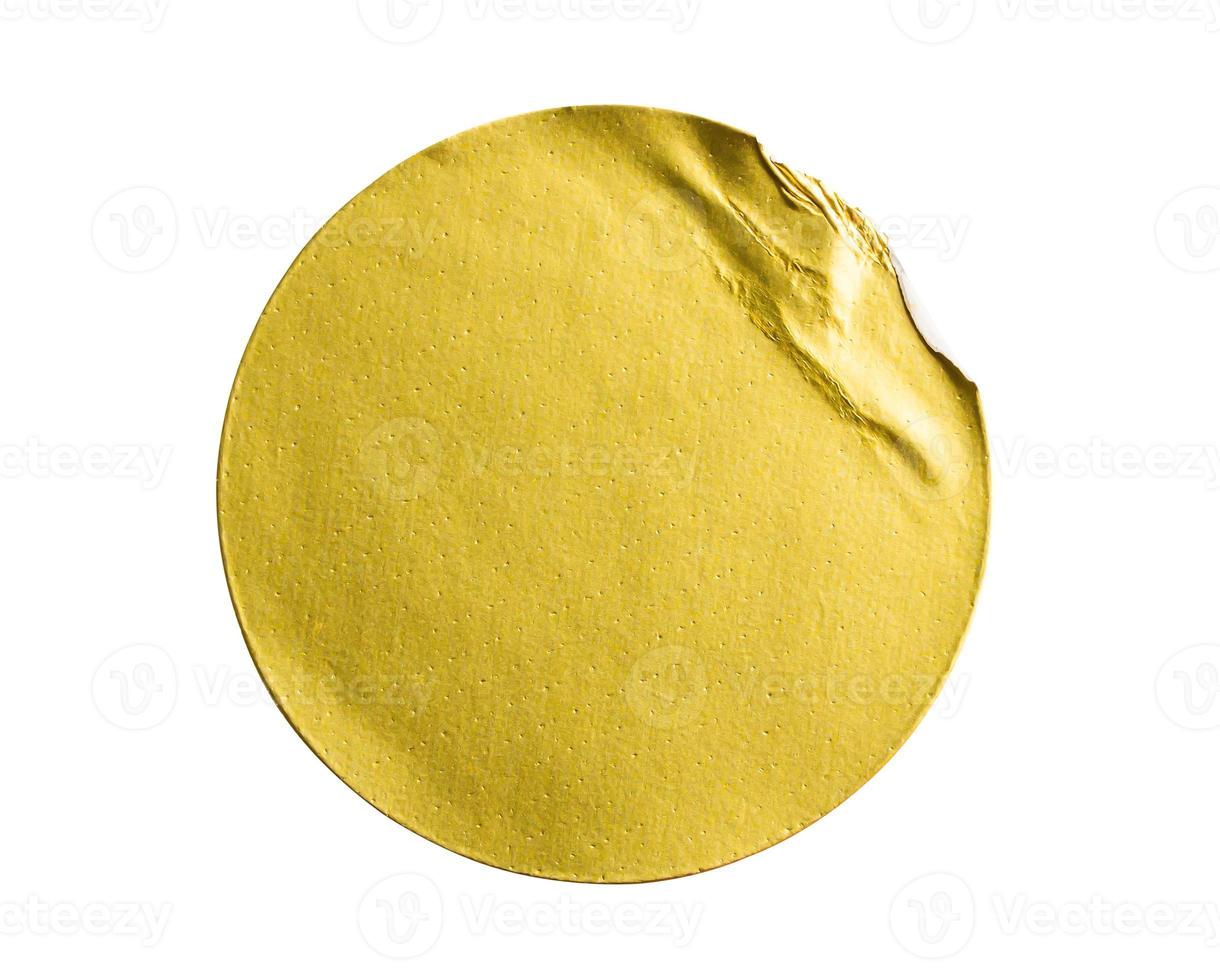 Blank golden round adhesive paper metallic sticker label isolated on white background photo