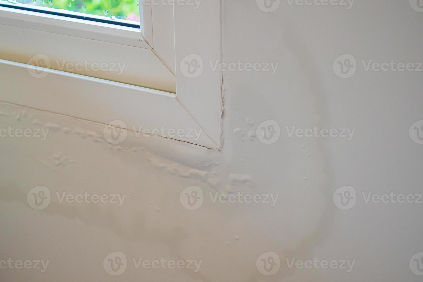 house wall near the window with some water stain show peeling paint photo