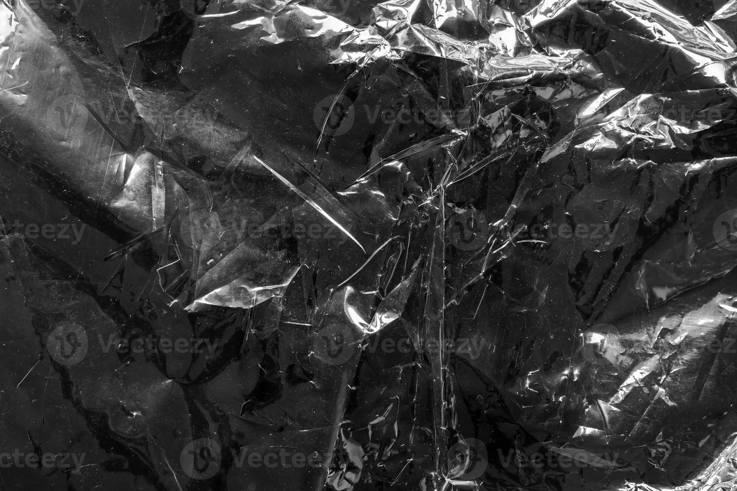 transparent plastic bag film wrap overlay texture on black background photo