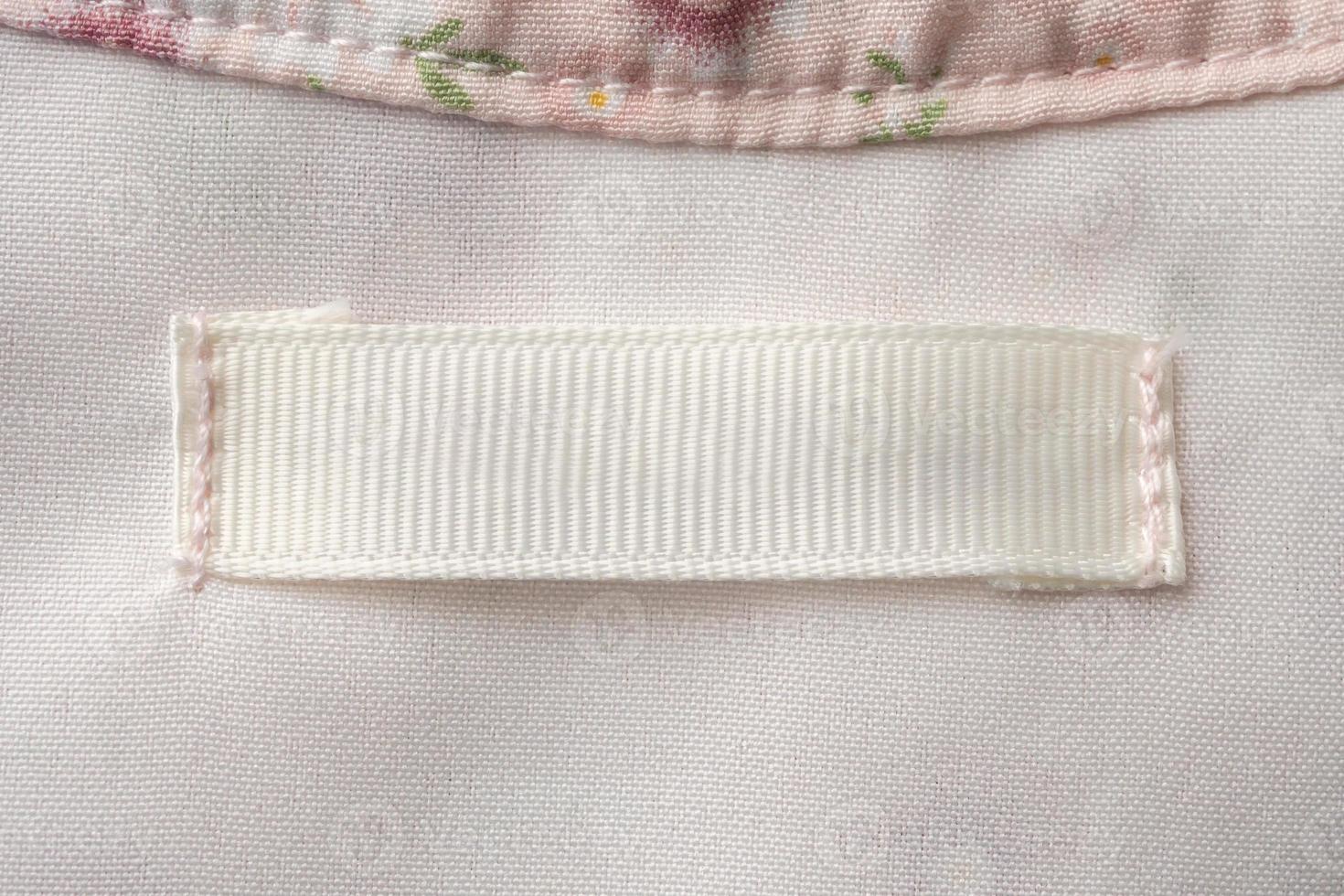 Blank laundry care clothes label on fabric texture background photo