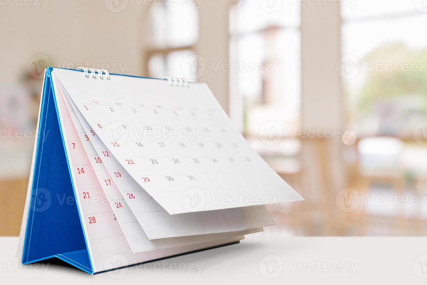 desk calendar on table with blurred bokeh background appointment and business meeting concept photo