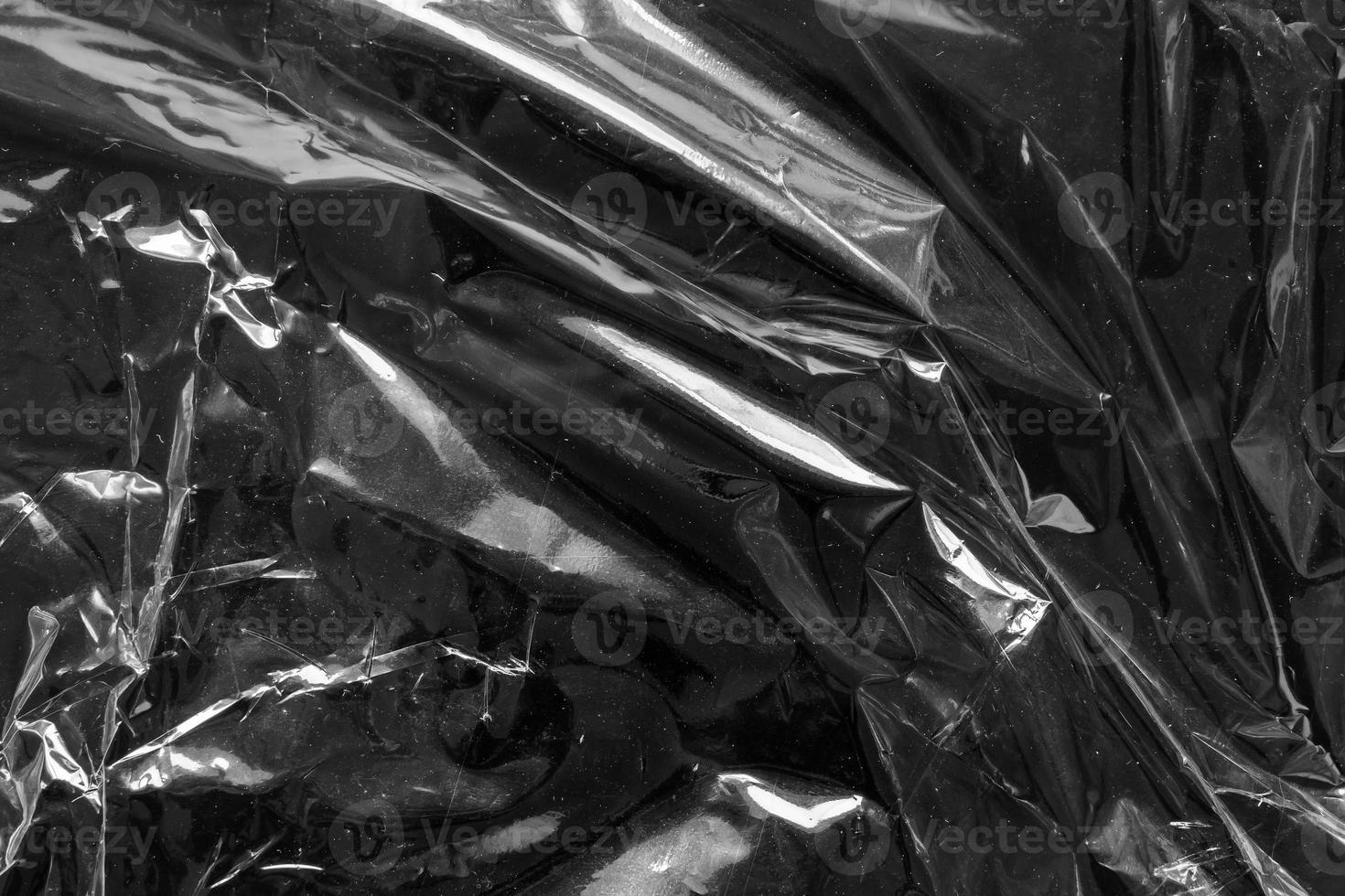 transparent plastic bag film wrap overlay texture on black background photo