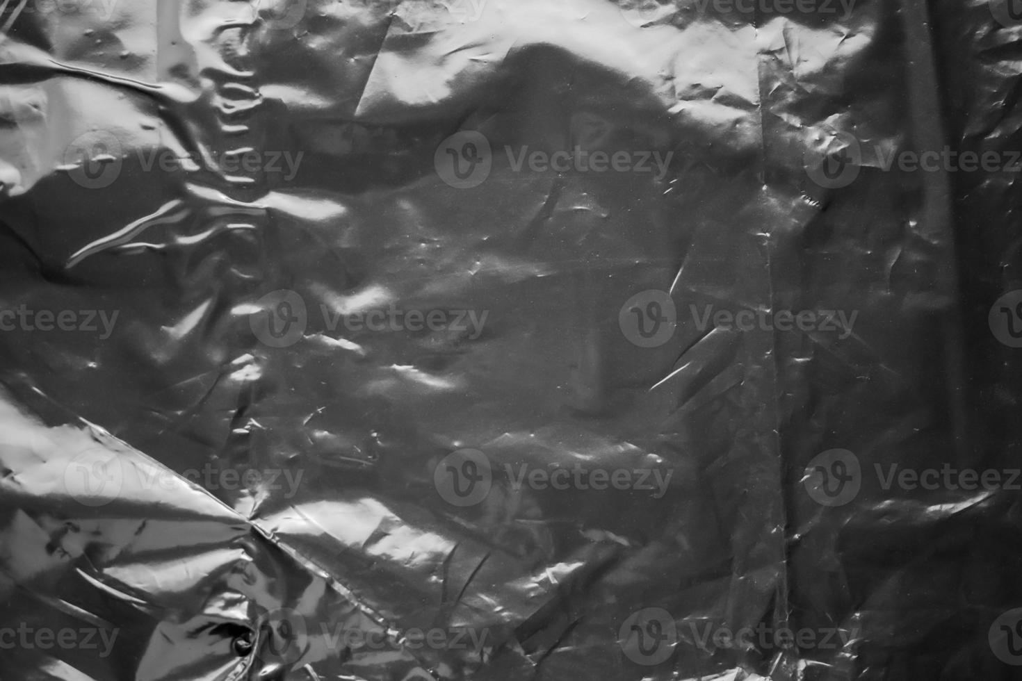transparent plastic bag wrap overlay texture on black background photo