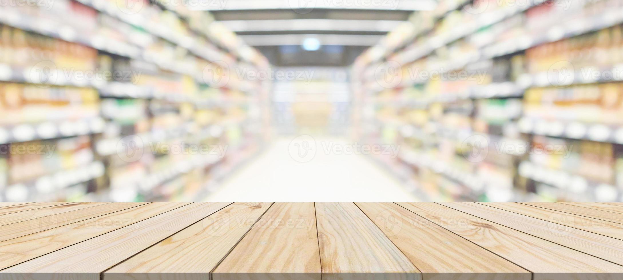 Wood table top with supermarket grocery store aisle interior blurred background with bokeh light for product display photo