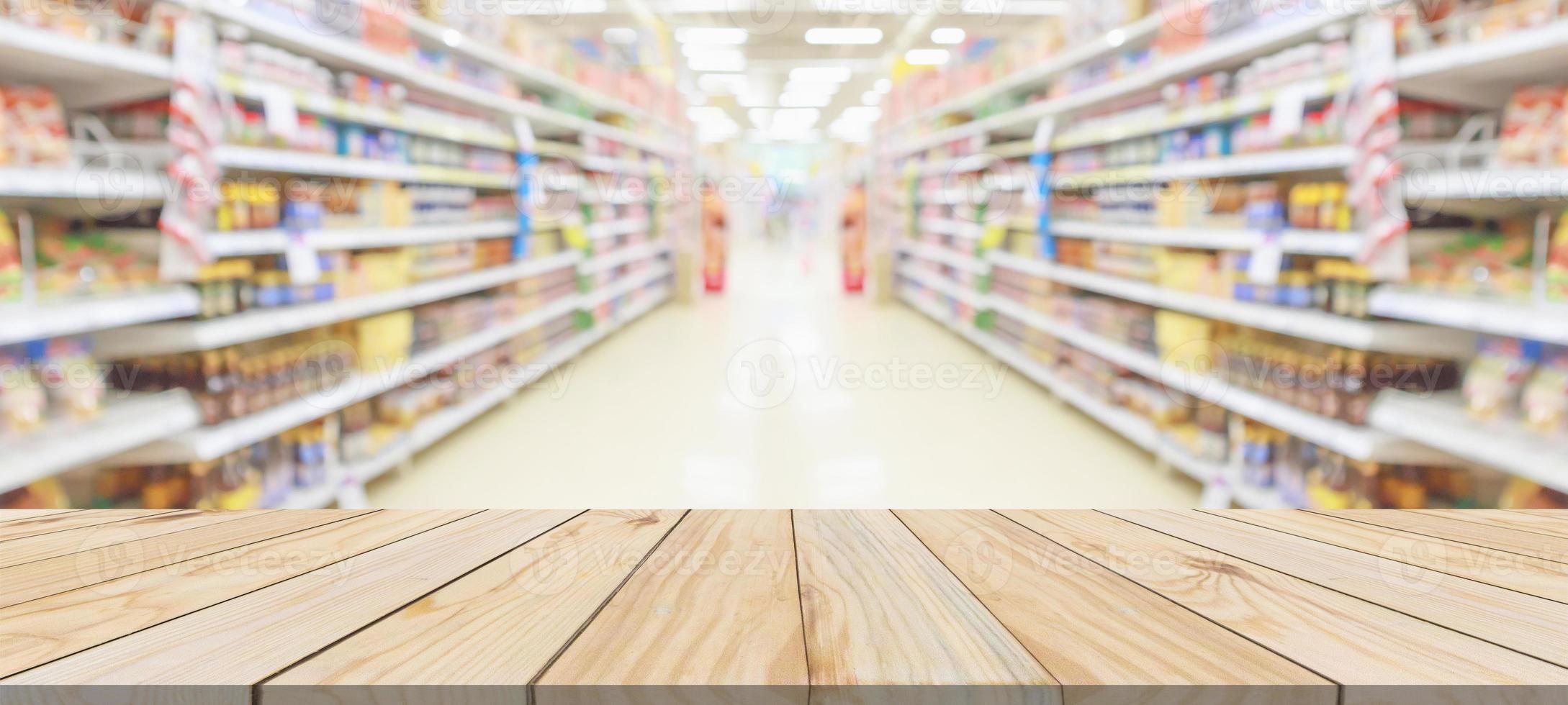 Wood table top with supermarket grocery store aisle interior blurred background with bokeh light for product display photo