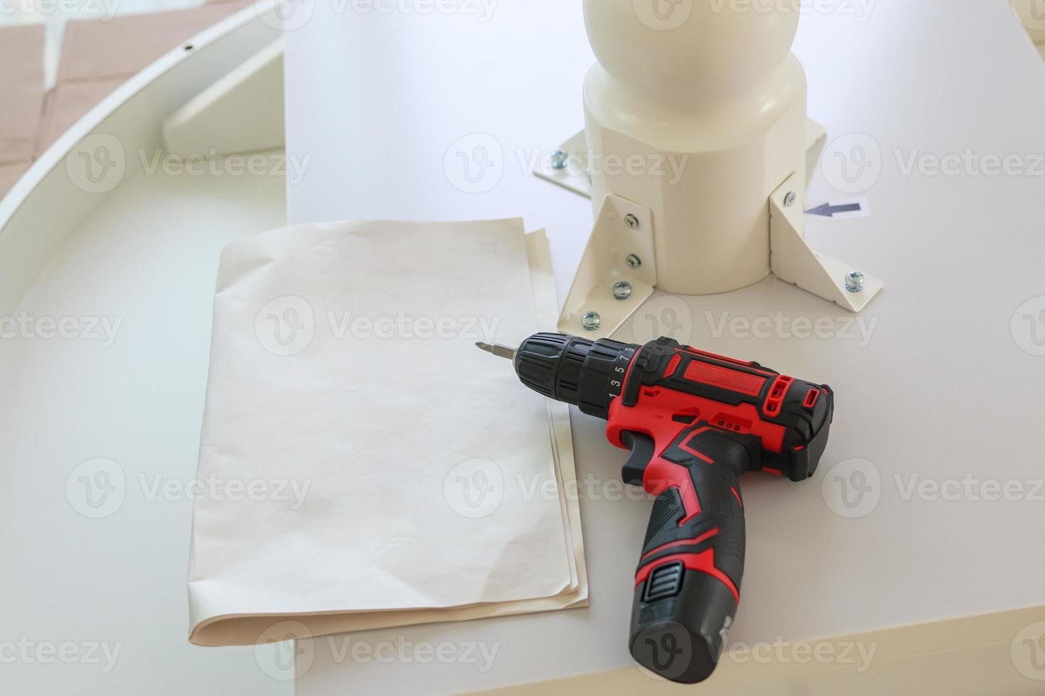 Cordless screwdriver on wood table assembly furniture concept photo