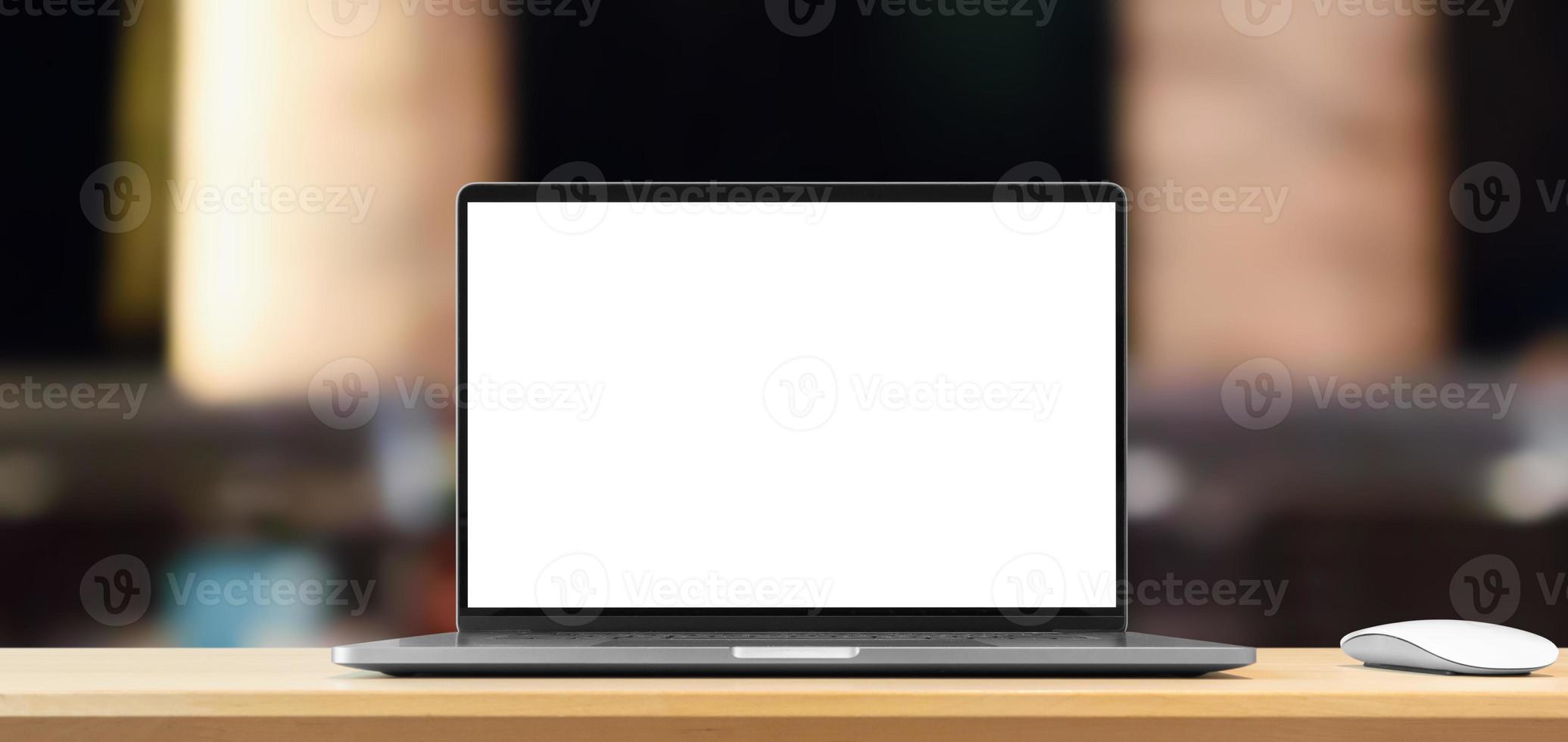 Laptop with blank screen on wood table with cafe coffee shop blur background photo