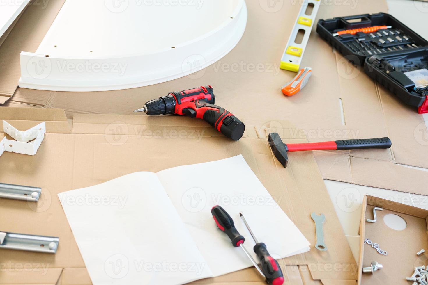 Cordless screwdriver and tool on cardboard paper assembly furniture concept photo