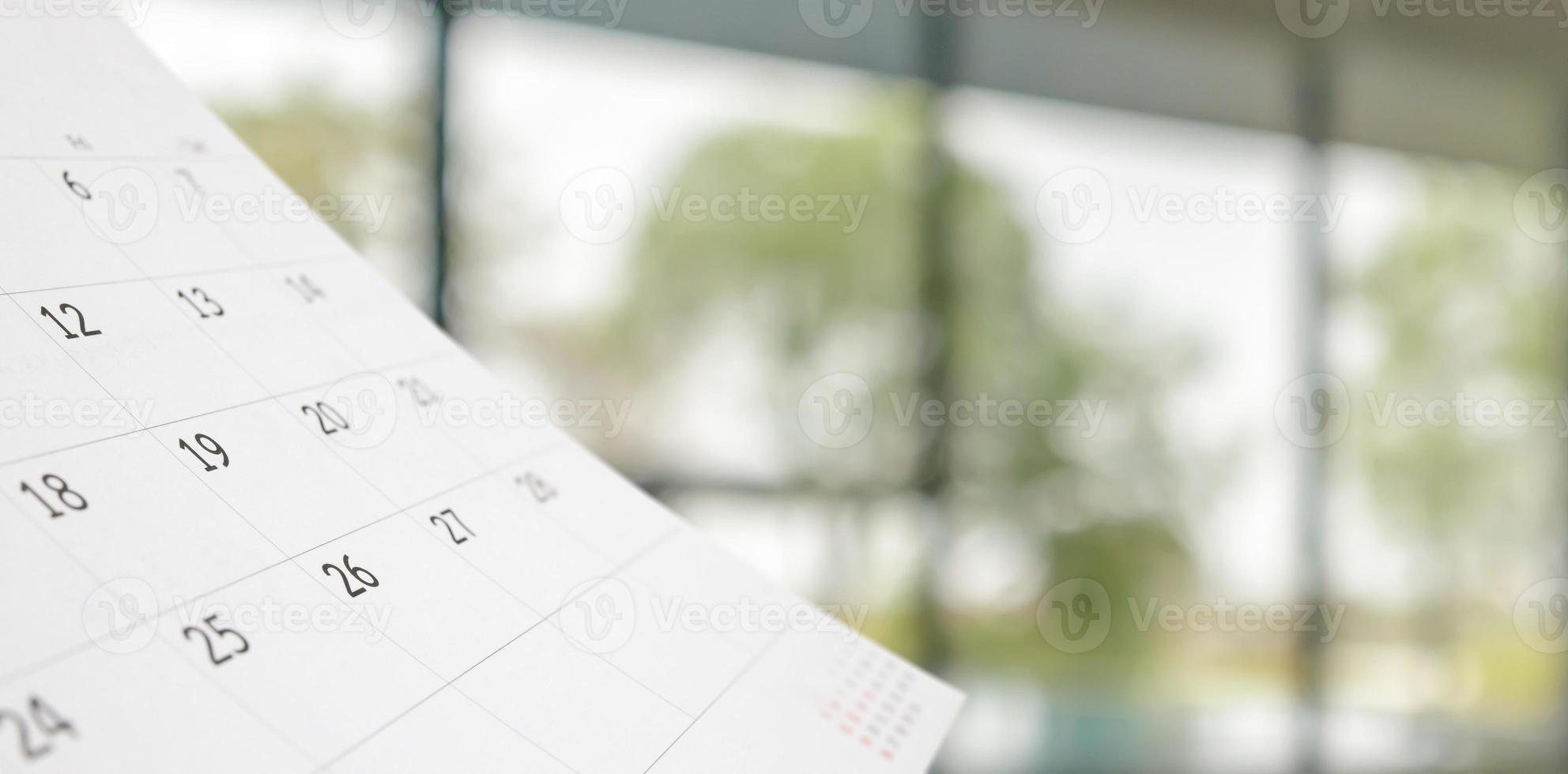 Close up white paper desk calendar with blurred bokeh background appointment and business meeting concept photo