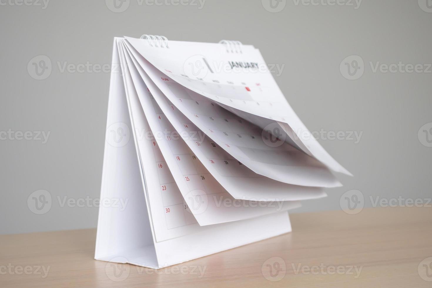 Calendar page flipping sheet on wood table background business schedule planning appointment meeting concept photo