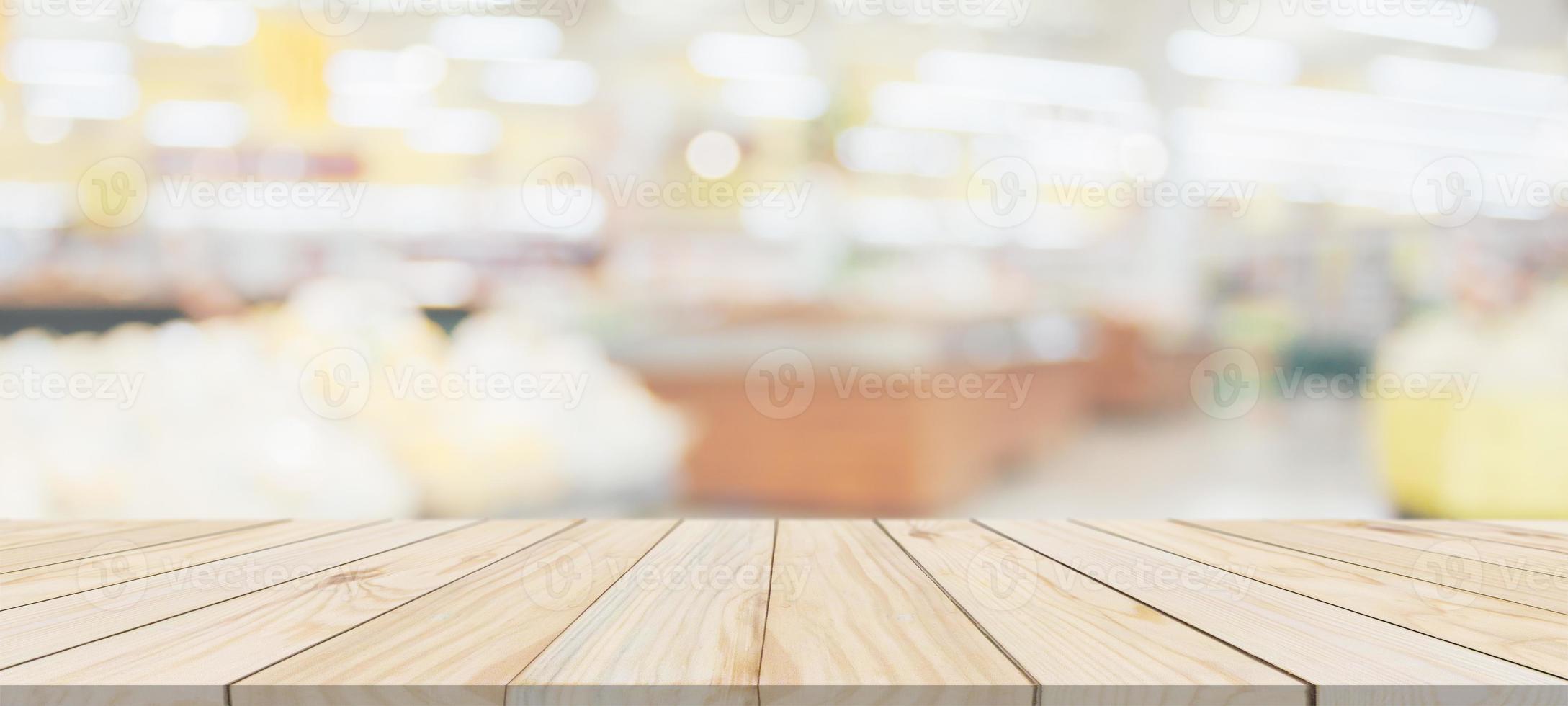 Wood table top with supermarket grocery store blurred background with bokeh light for product display photo