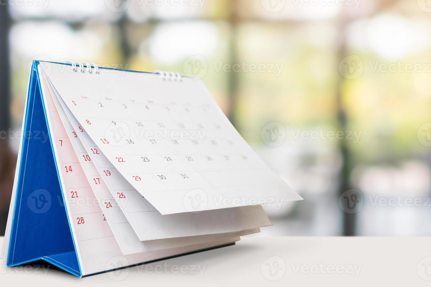 desk calendar on table with blurred bokeh background appointment and business meeting concept photo