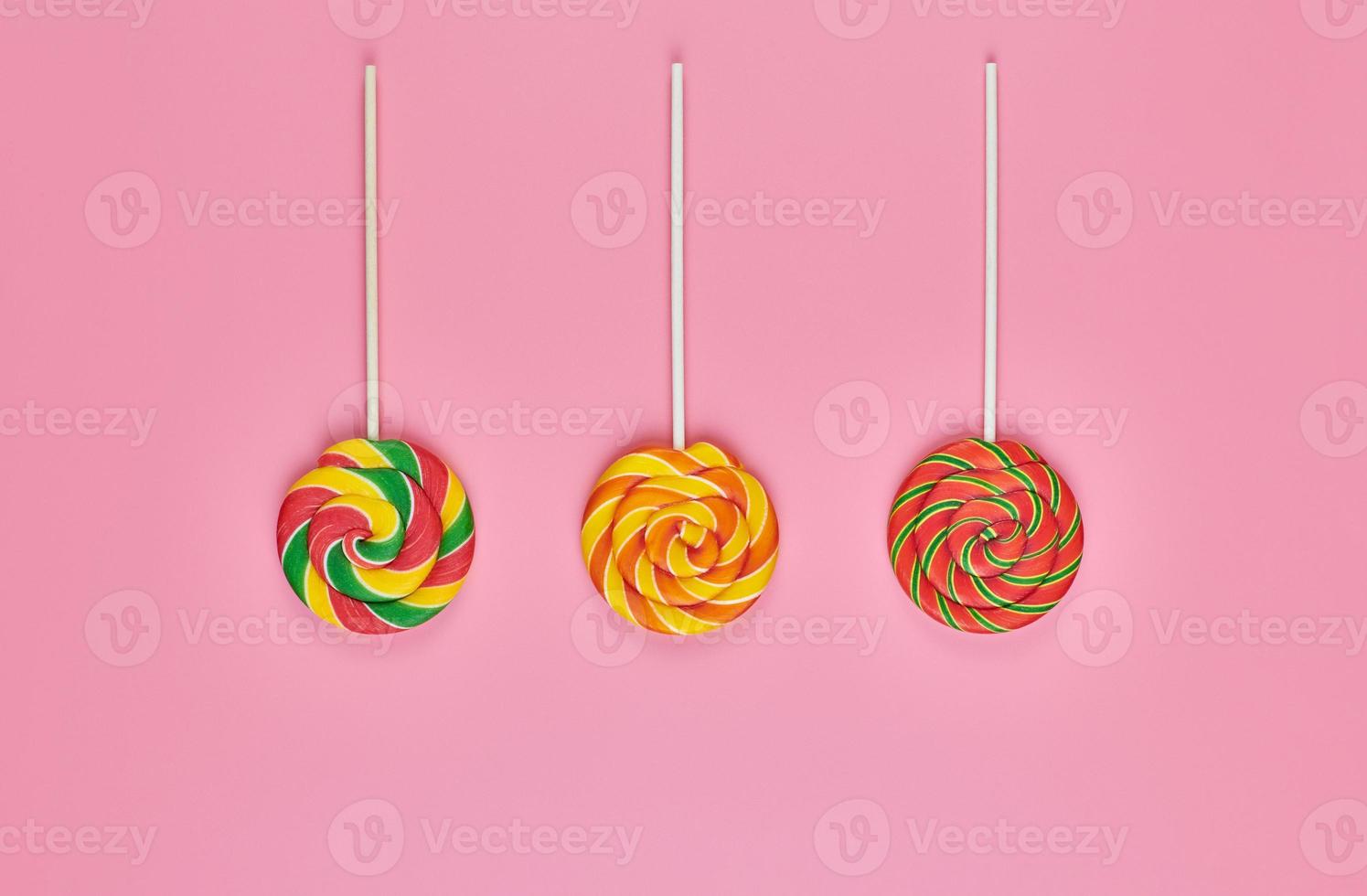 Sweet lollipops on pink background photo